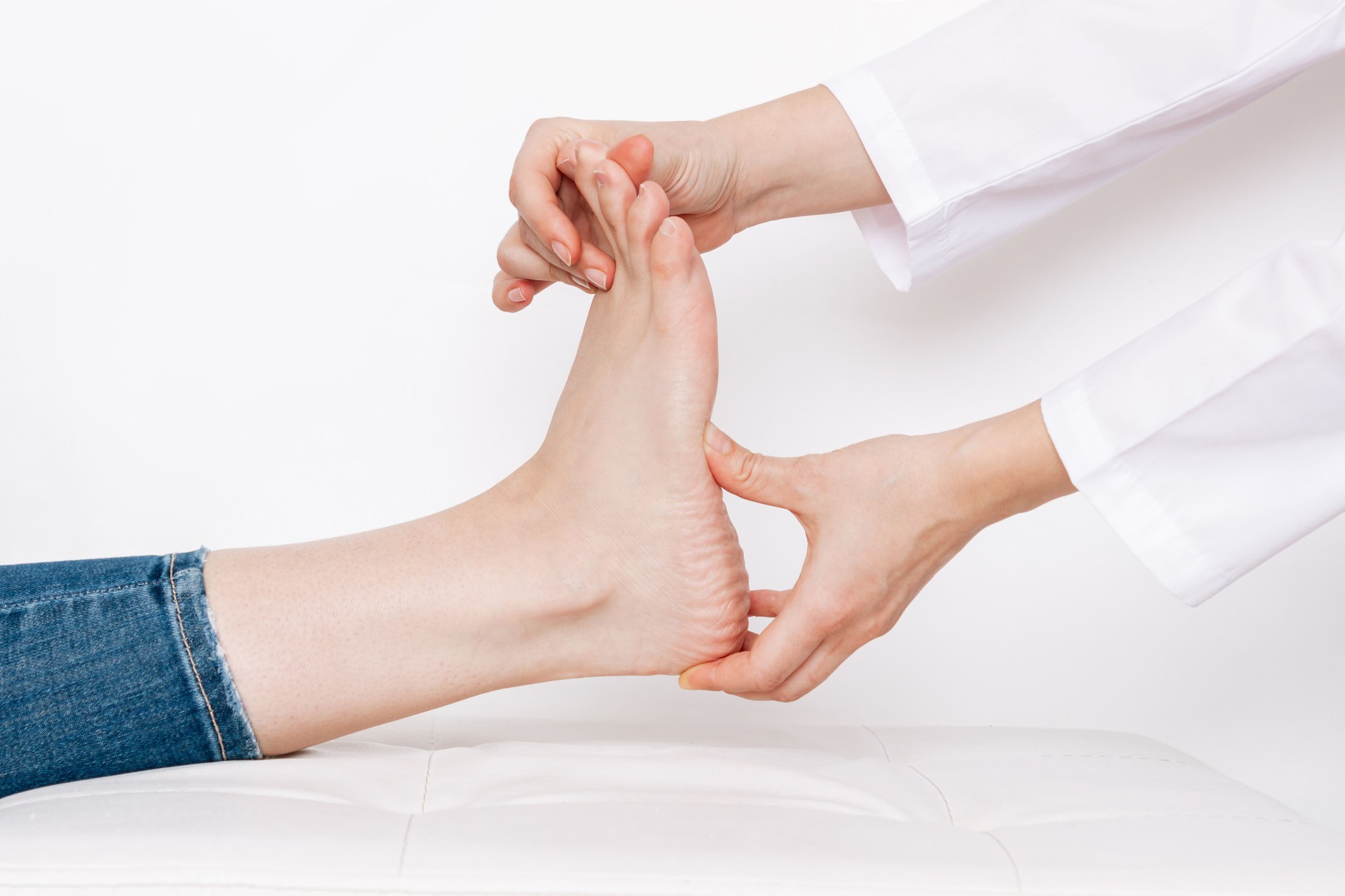 Examination of a young woman by an female orthopedist. Cropped shot of doctor holding a painful foot